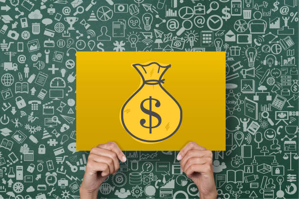 Businesswoman holding placard with dollar bag icon in front of green chalkboard