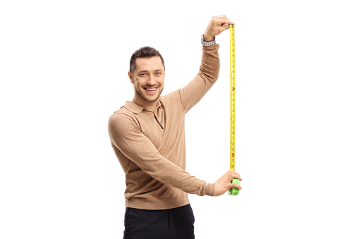 Young guy with a measuring tape looking at the camera and smiling isolated on white background