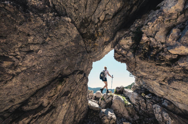 Summer Hiking Woman hiking in the mountains (Kamnik-Savinja Alps, Slovenia). View through rock window. steep photos stock pictures, royalty-free photos & images