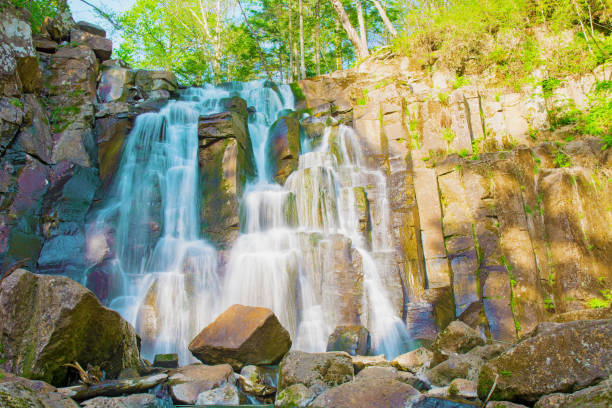 istock beautiful forest waterfall. on the stony slope runs stormy forest waterfall. 819730962