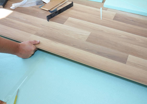 istock Contractor installing wooden laminate flooring with insulation and soundproofing sheets. Man laying laminate flooring. Man laying laminate flooring. 819734820