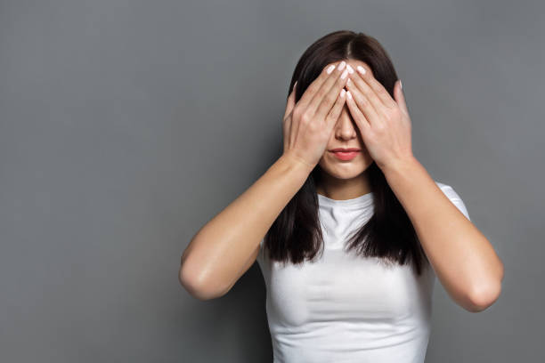 istock Scared woman covering eyes with hands, see no evil 819743130