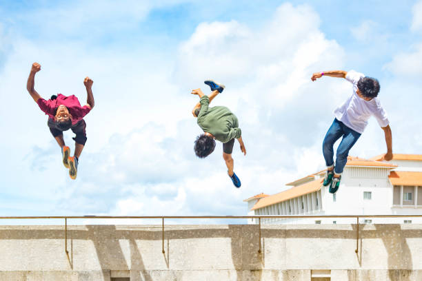 Parkour 2 Three adolescent males perform flips off a high ledge free running stock pictures, royalty-free photos & images