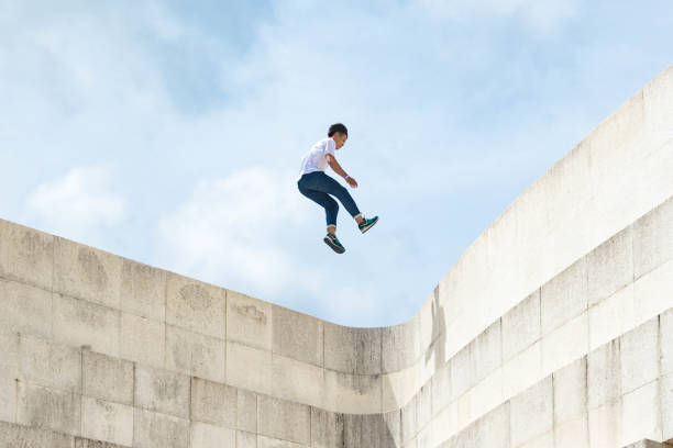 Leap Across A Gap An adolescent Japanese male leaps across a large gap leap of faith stock pictures, royalty-free photos & images