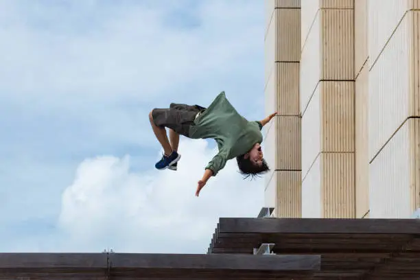 An adolescent Japanese male does a backflip