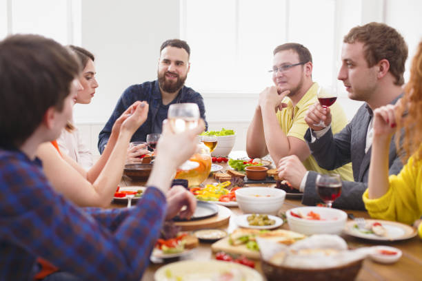 istock Group of happy people at festive table dinner party 819766010