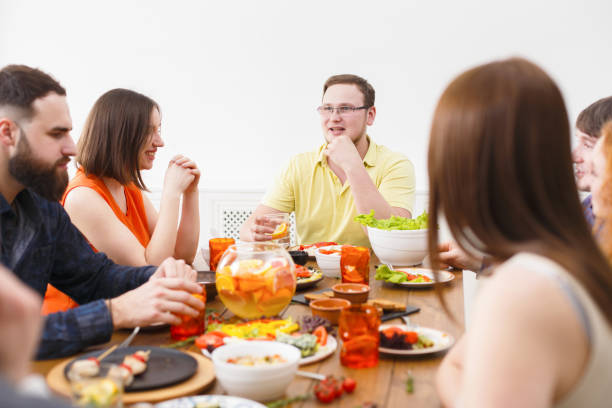 istock Group of happy people at festive table dinner party 819766584