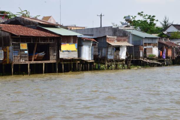 istock Decrepit Mekong Delta river bank corrigated iron housing falling into the delta 819767136