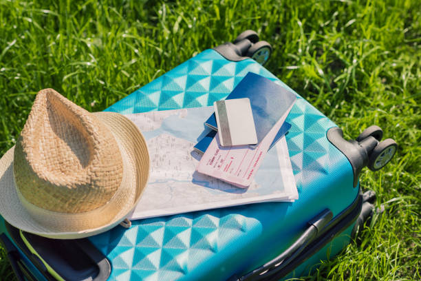 istock passports, tickets, map, credit card and straw hat lying on blue suitcase 819770972