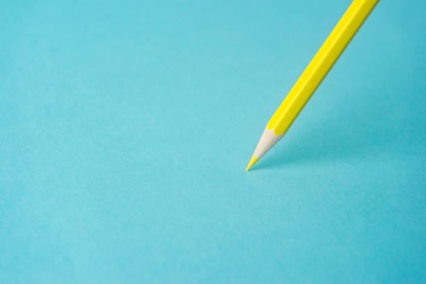 istock ne yellow color pencil stand on blue paper background 819775486