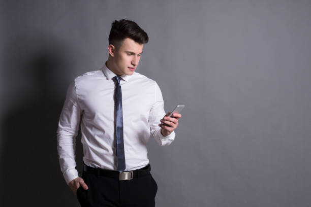 istock Confident businessman holding mobile phone. 819775782