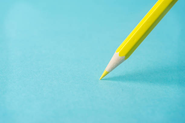 istock ne yellow color pencil stand on blue paper background 819778522