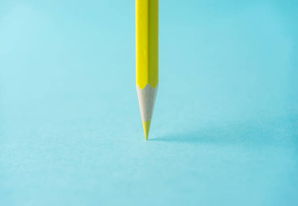 istock ne yellow color pencil stand on blue paper background 819780830