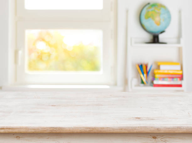 деревянный стол с размытым фоном детской комнаты и окна - school child education furniture стоковые фото и изображения