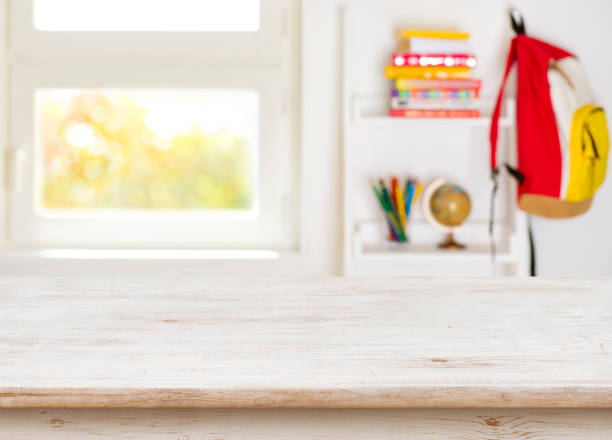 istock Wooden table over blurred background of junior schoolchild room interior 819784474