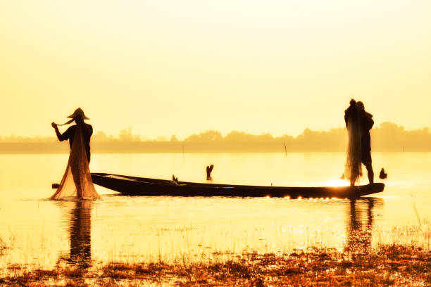 istock Fishing man in silhouette on gold sunset background. 819794076
