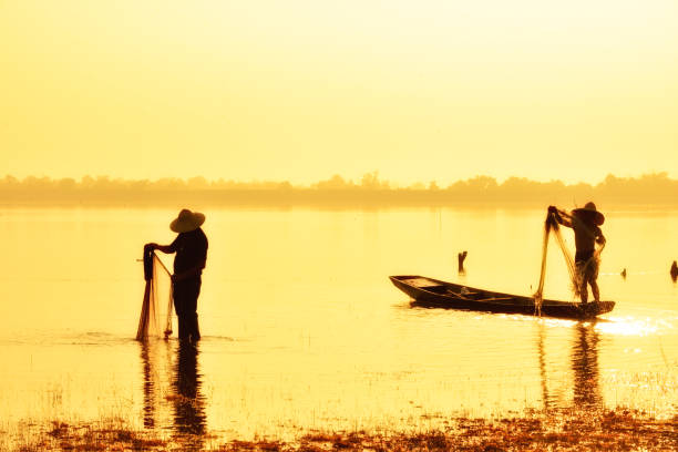 istock Fishing man in silhouette on gold sunset background. 819794094