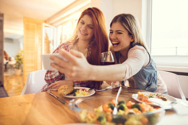 istock Young women having fun and taking a selfie during lunch time. 819799040