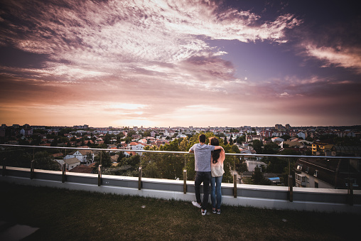 Loving couple spending morning together and enjoying in breathtaking view from their balcony. Copy space.