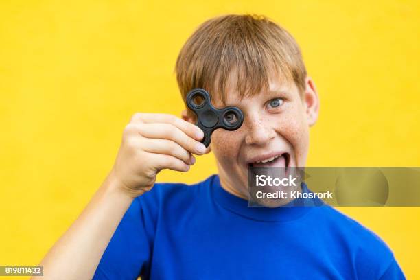 Muchacho Con Spinner Fidget Sobre Fondo Amarillo Foto de stock y más banco de imágenes de A la moda - A la moda, Adolescente, Agarrar