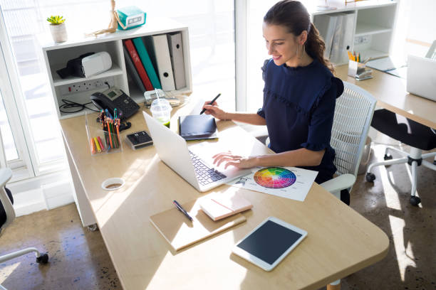istock Female executive working over graphic tablet at her desk 819811734