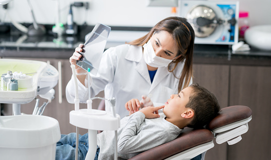 Dentista feliz mirando una radiografía con su paciente joven photo