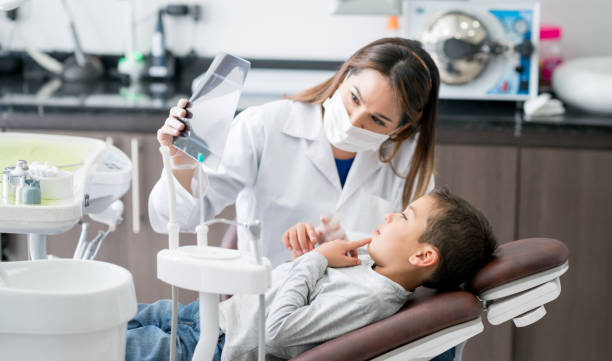 dentista feliz mirando una radiografía con su paciente joven - imagen de rayos x fotos fotografías e imágenes de stock