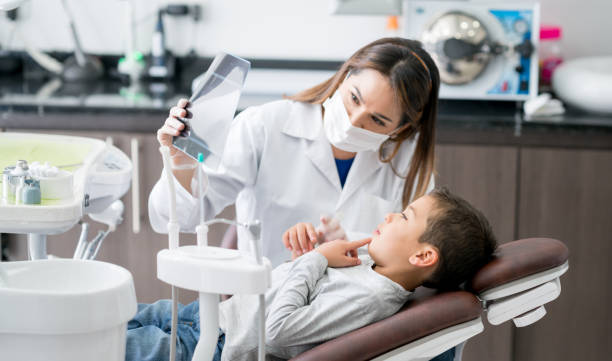 Happy dentist looking at an x-ray with his young patient