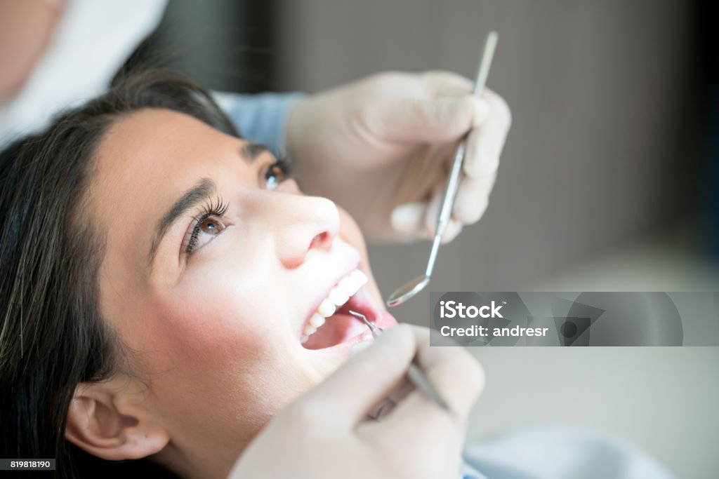 Portrait of a woman at the dentist Portrait of a beautiful woman at the dentist getting her teeth checked - oral health concepts Dental Health Stock Photo