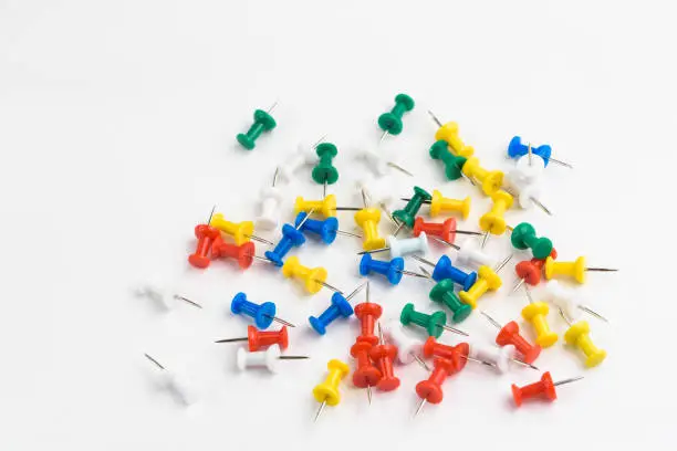 Photo of various colors pushpins on white background