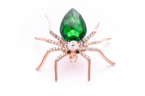 istock Golden spider with a big green stone isolated on white 819833176