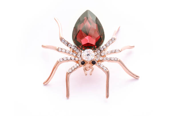 istock Golden spider with a big red stone isolated on white 819833180