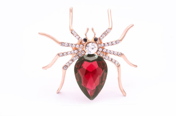 istock Golden spider with a big red stone isolated on white 819833222