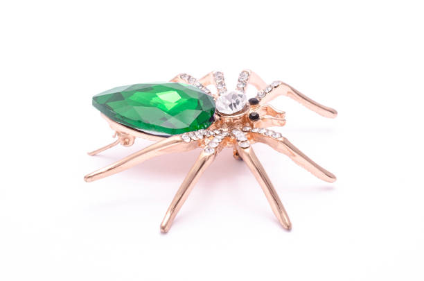 istock Golden spider with a big green stone isolated on white 819833242