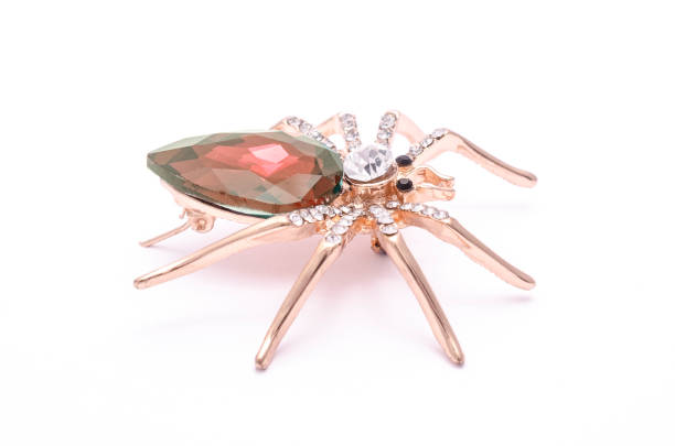 istock Golden spider with a big red stone isolated on white 819833250