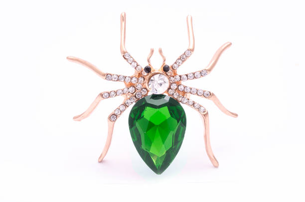 istock Golden spider with a big green stone isolated on white 819833470