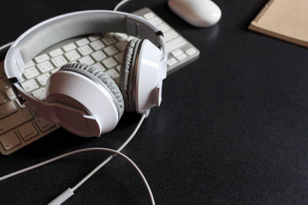 istock white headphone and desktop computer on black wooden with soft-focus in the background. over light and film colors tone 819834532
