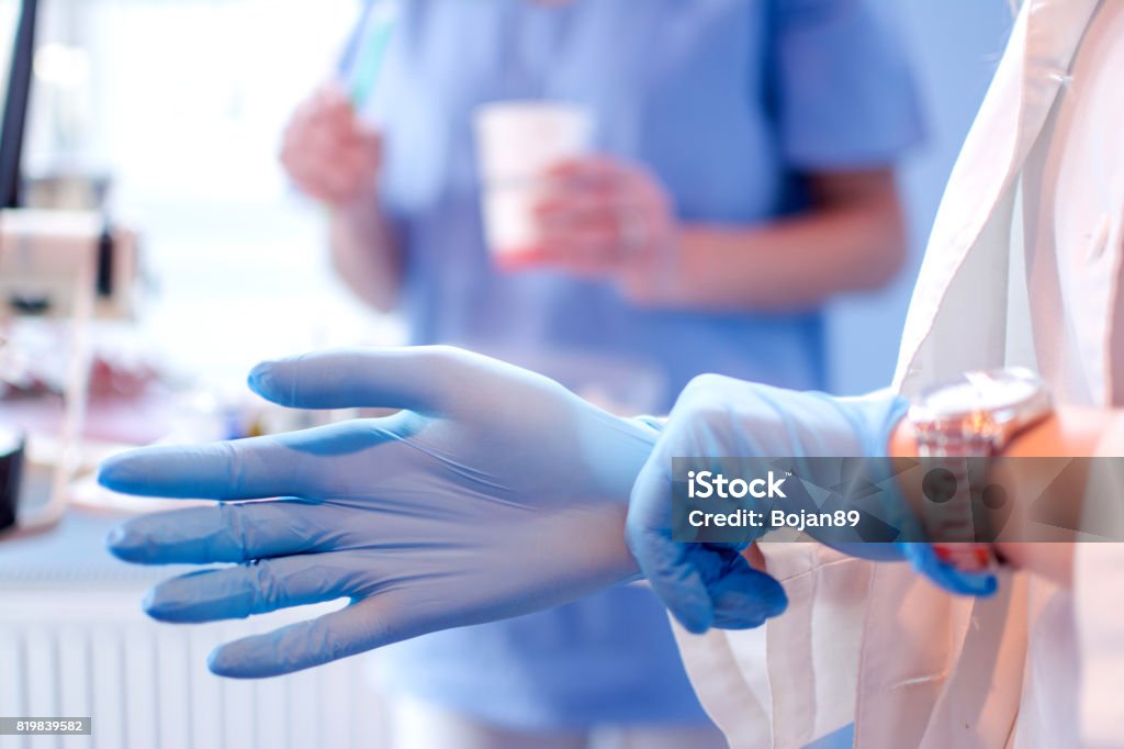 Nahaufnahme des weiblichen Arzt Hände aufsetzen blau sterilen OP-Handschuhen in der medizinischen Klinik. - Lizenzfrei Handschuh Stock-Foto