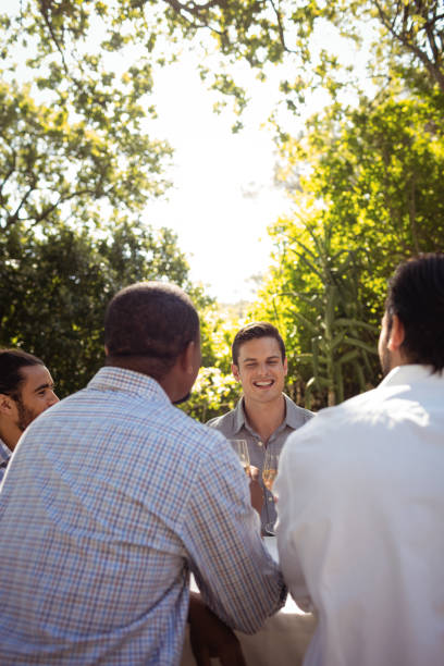 istock Group of friends interacting with each other while having champagne 819870788