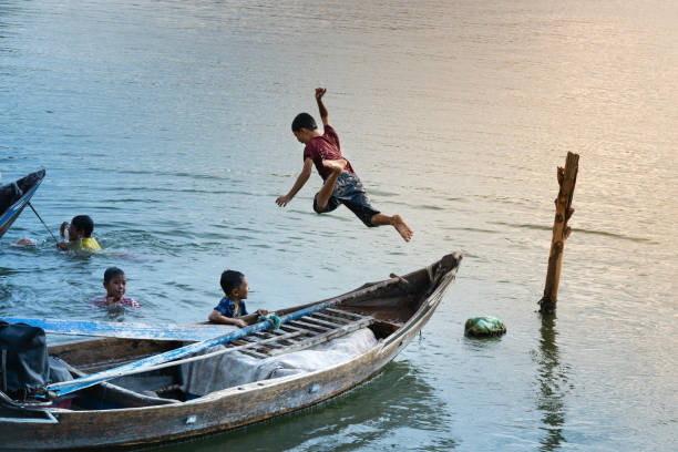 crianças rurais pulou no rio para se banhar e jogando em uma pequena aldeia na província de phu yen, vietnã - salta province - fotografias e filmes do acervo