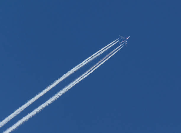 istock Aircraft and Diagonal Condensation Trails or Contrails on blue sky 819883092