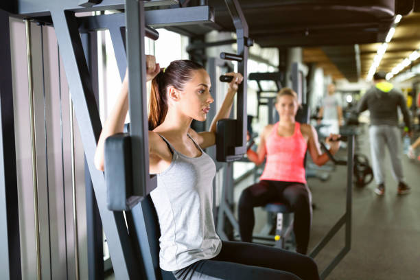istock Young women exercising on machine in gym 819897542