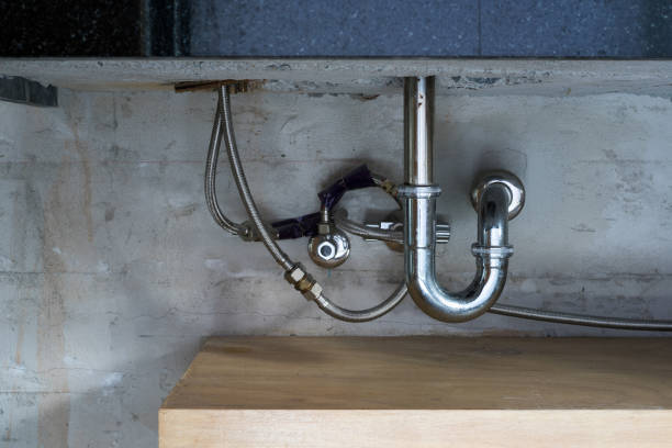 Bathroom steel sink pipes, trap and drain on concrete wall stock photo