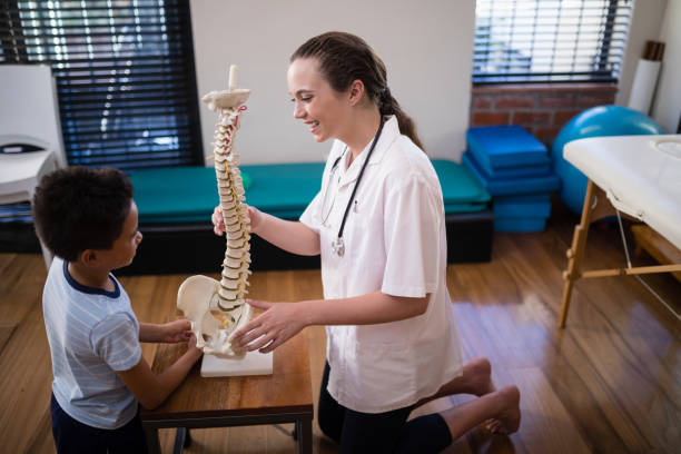 chiropractor explaining to a student with artificial spine