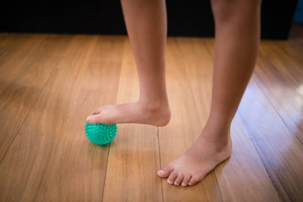 istock Low section of boy standing while stepping on stress ball 819928774