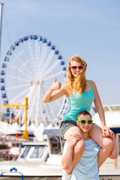istock Man giving girlfriend piggyback ride on marina 819935132