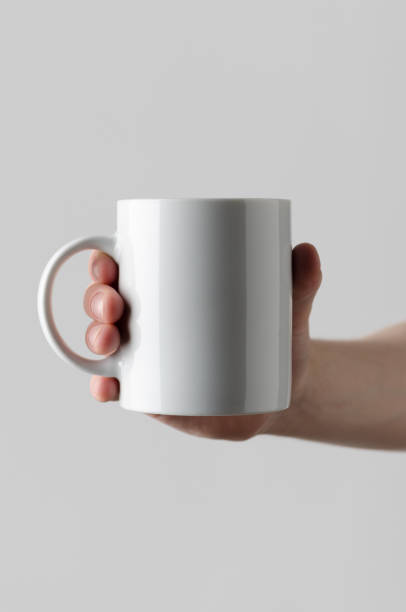 istock Mug Mock-Up - Male hands holding a mug on a gray background 819935314