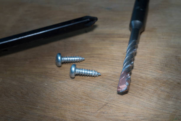istock Drill bits on rugged wood with screws and screwdrivers 819938228