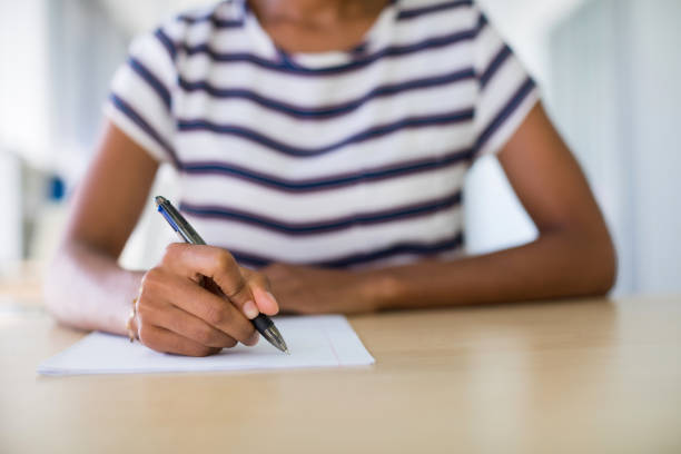 istock Female executive writing on paper at her desk 819946794