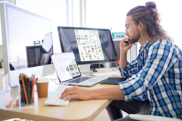 Male executive working at his desk Male executive working at his desk in office graphic designer stock pictures, royalty-free photos & images